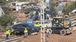 Workers remove cars littered across train tracks in Valencia floodhit area  AFP [upl. by Atinrev560]