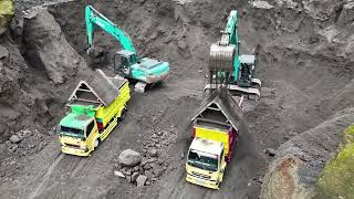 Two Kobelco excavators work digging sand and loading sand onto trucks [upl. by Ojyllek]