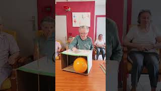 Players push long pins through a cardboard box attempting to pop the balloon [upl. by Ecyal]