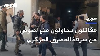 عناصر من الفصائل يهرعون لمنع لصوص من سرقة المصرف المركزي في دمشق  AFP [upl. by Enitsyrhc]